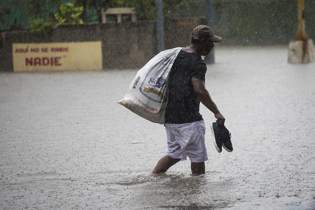 Ein Mann läuft durch eine überflutete Straße in Havanna