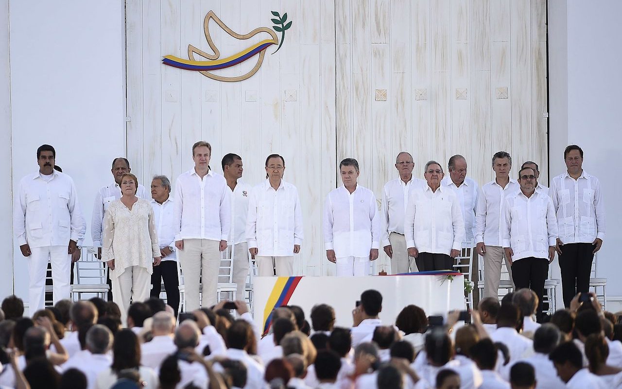 Personen stehen in einer Reihe vor weißem Grund bei Friedensverhandlungen in Kolumbien 2016