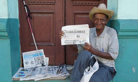 Ein Mann verkauft eine Zeitung in Kuba