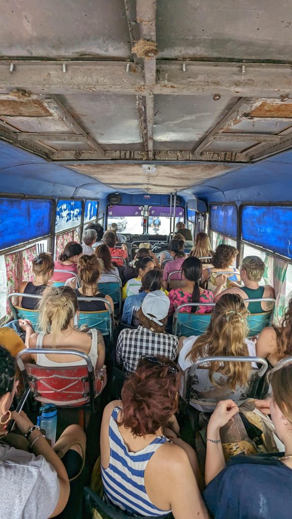 Zu sehen ist eine Reisegruppe in einem älteren rustikalen Bus