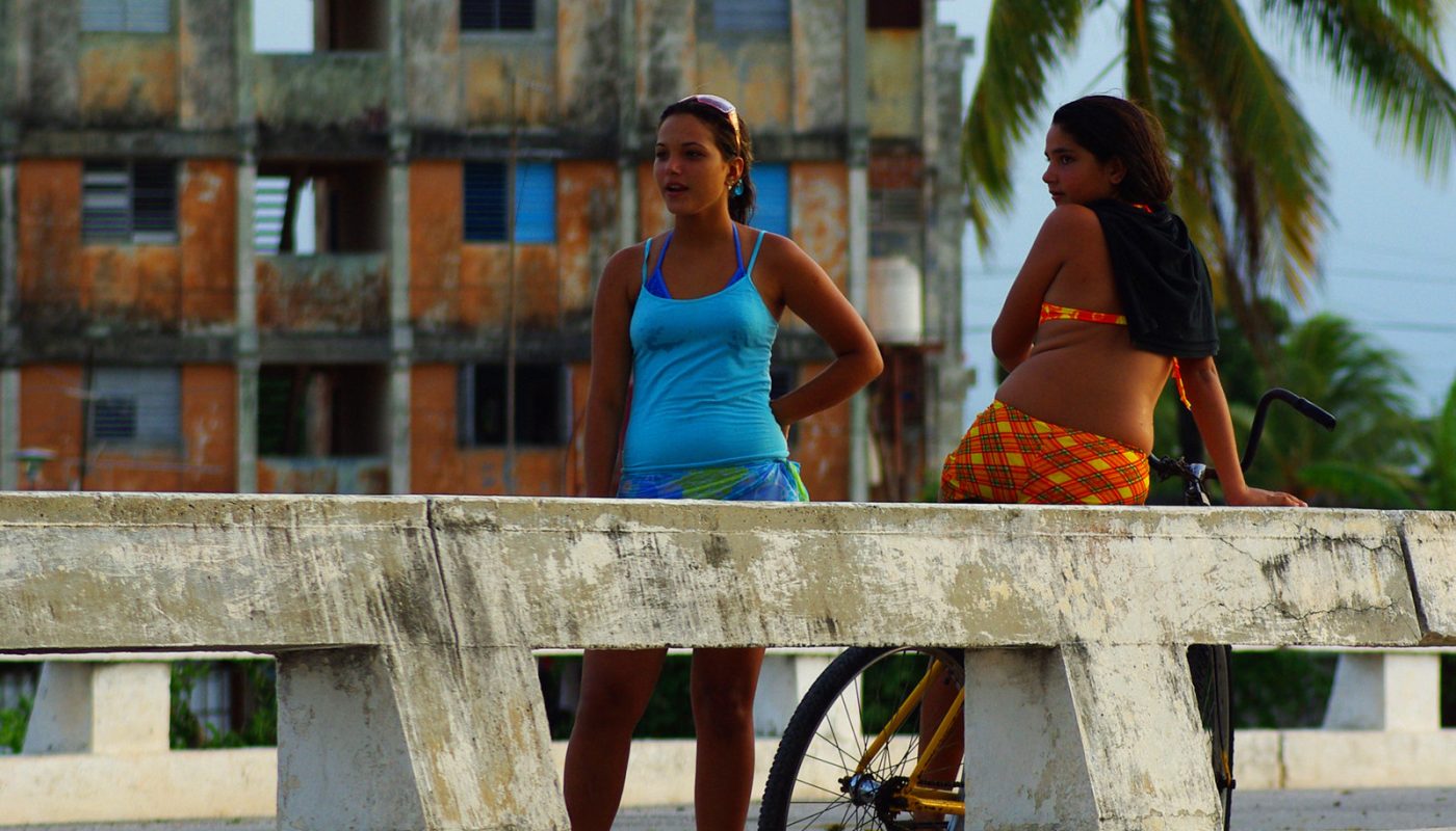 Zwei Frauen am Straßenrand in Havanna, im Hintergrund ein Haus